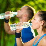 Man and woman drinking water from bottle after fitness sport exercise