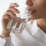 Dehydrated woman feeling thirsty holding glass drinking water, h